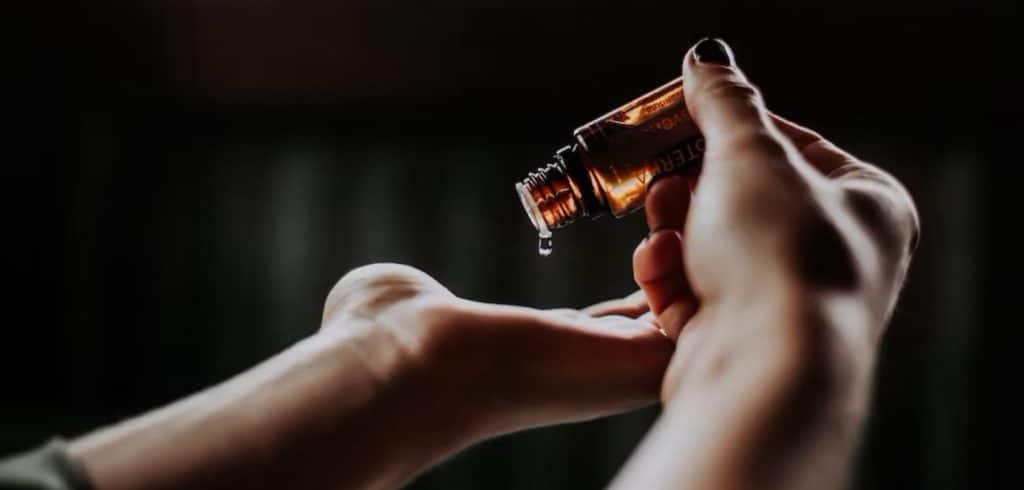 hands holding a glass vial - new labelling rules for fragrance allergens