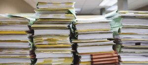 several stacks of thick folders on a table - cosmetic product safety report (CPSR)