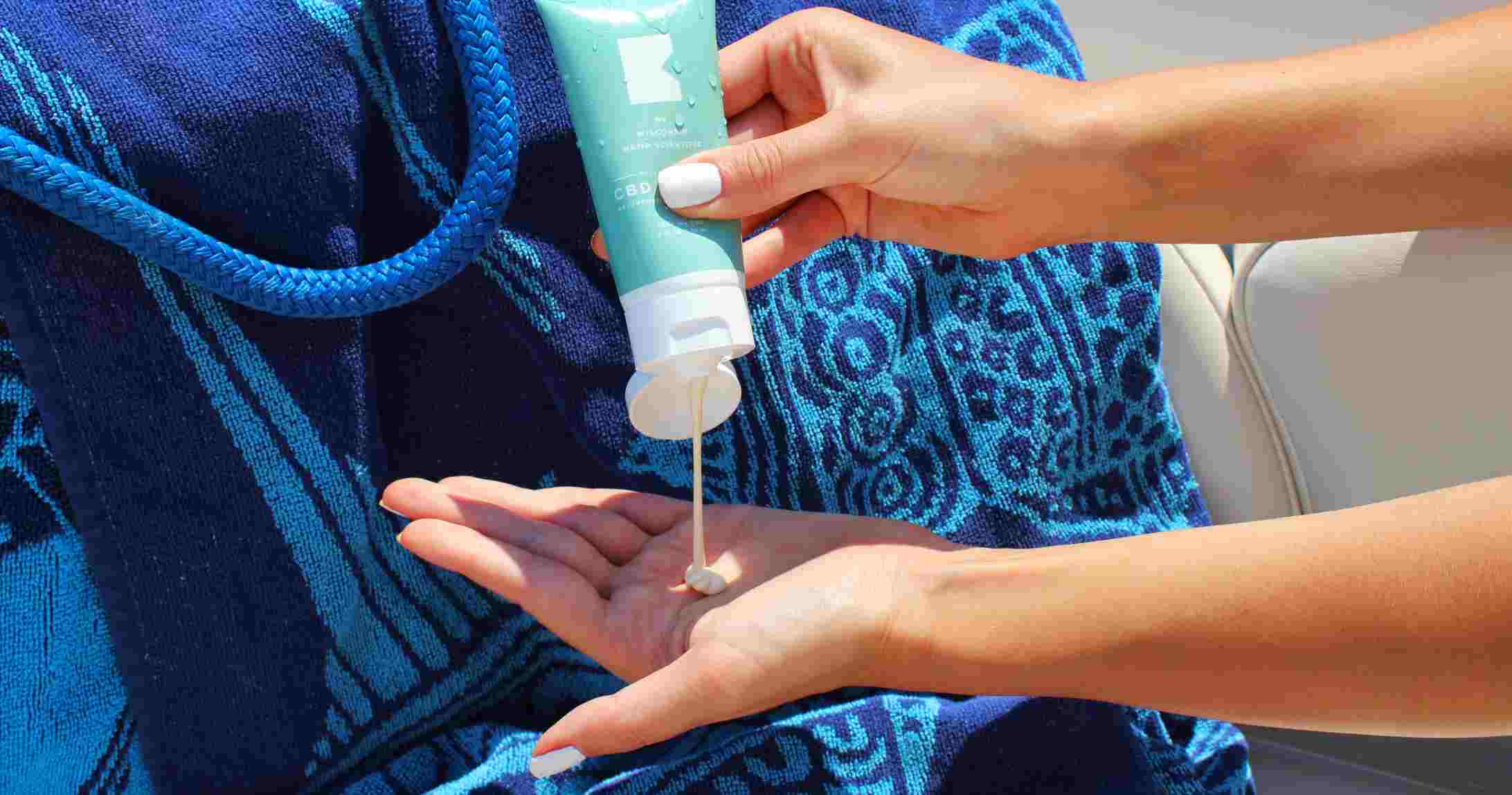 woman squeezing sunscreen product in her hand