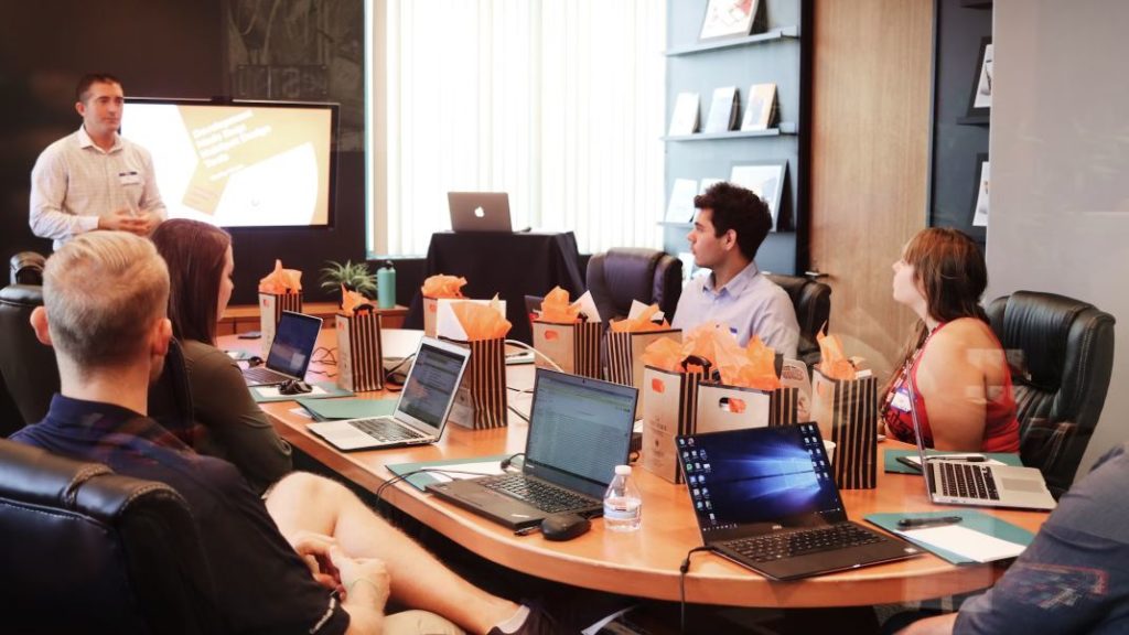 people attending a meeting in a conference room - cosmetovigilance in cosmetics regulations