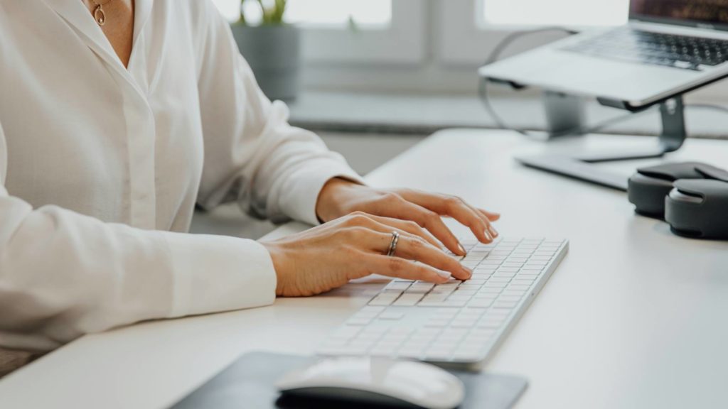 Woman working at a computer - submit cosmetic product notification SCPN UK process