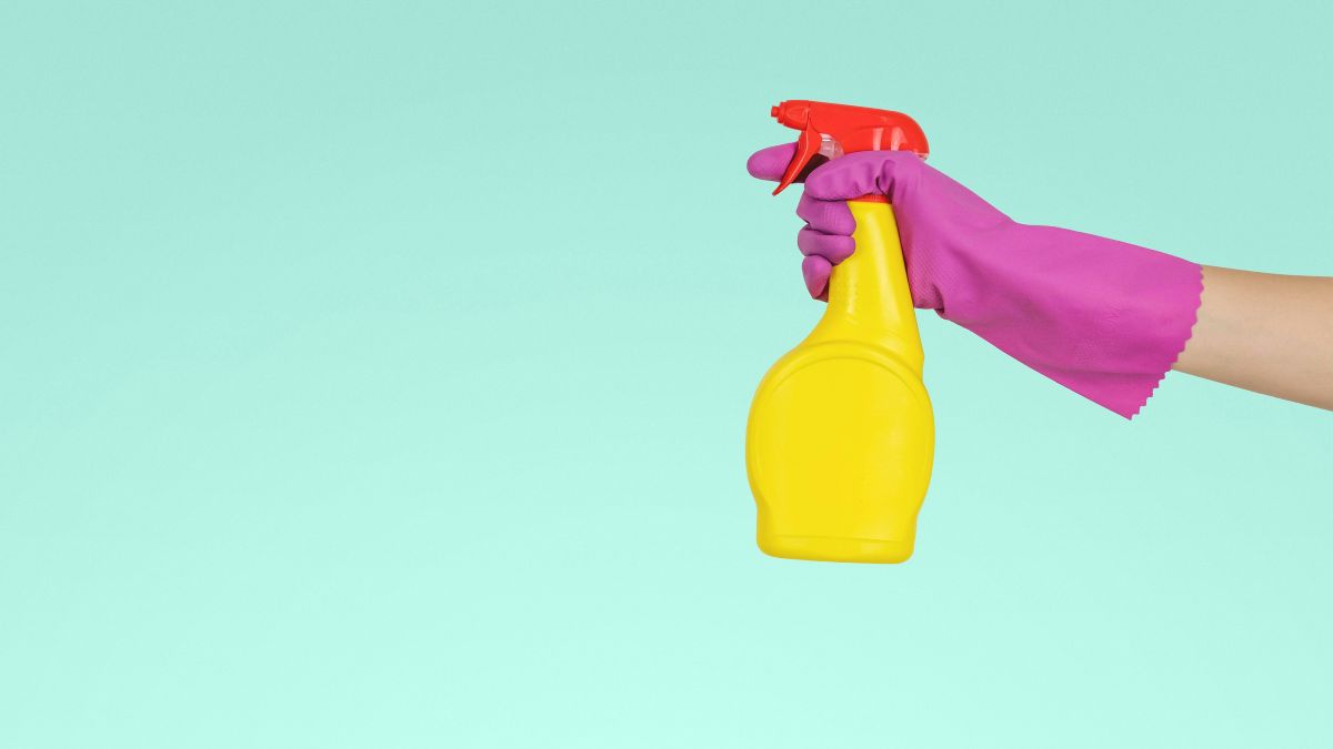 a hand in a glove holding a spray bottle - safety and transparency in the detergent sector