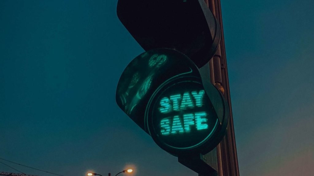 a green traffic light with the words stay safe displayed in green