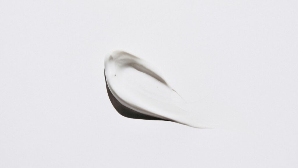 close-up of a white, creamy smudge of sunscreen on a white background