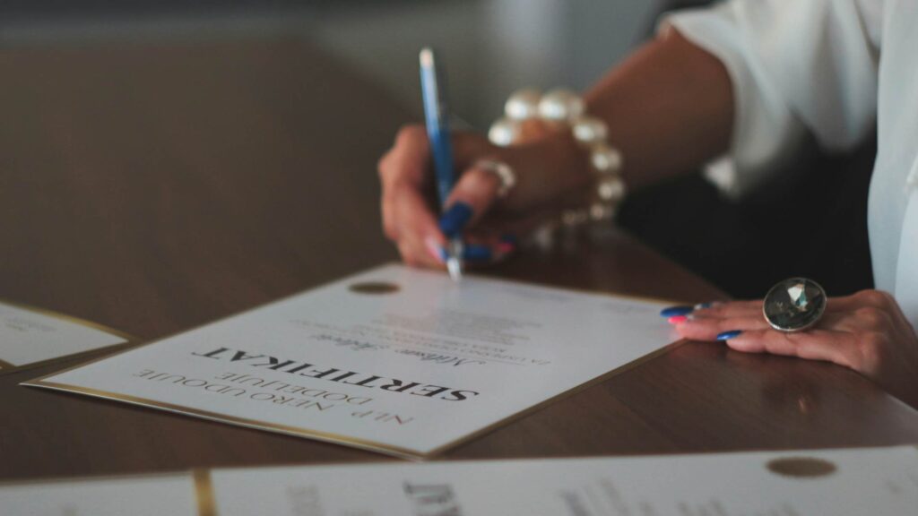 close-up of a woman's hand signing a vegan cosmetics compliance certification